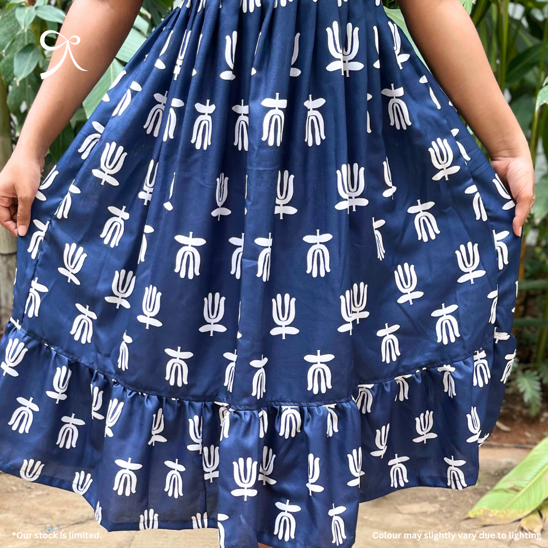 Model wearing Devrobes Navy Linen Handblock Maxi Dress with white handblock motifs and tiered silhouette – breathable and elegant outfit. Page maintained by Creations by Nash.